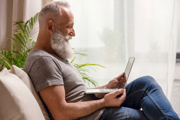 Homme âgé utilisant un ordinateur portable — Photo de stock