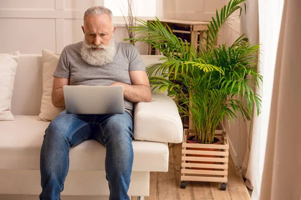 Uomo anziano utilizzando il computer portatile — Foto stock
