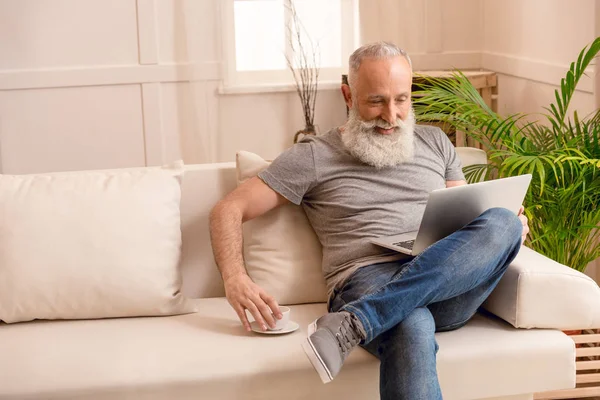 Homme âgé utilisant un ordinateur portable — Photo de stock