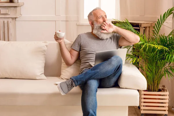 Uomo anziano utilizzando il computer portatile — Foto stock