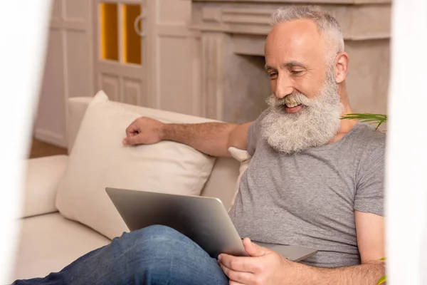 Uomo anziano utilizzando il computer portatile — Foto stock