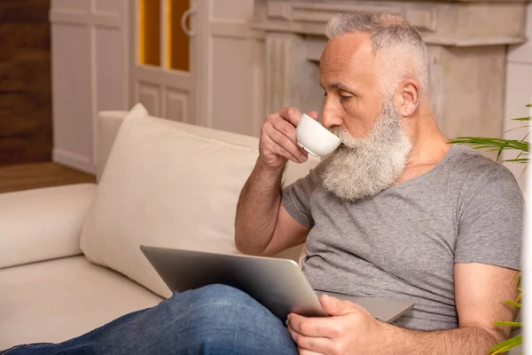 Hombre mayor usando portátil — Stock Photo