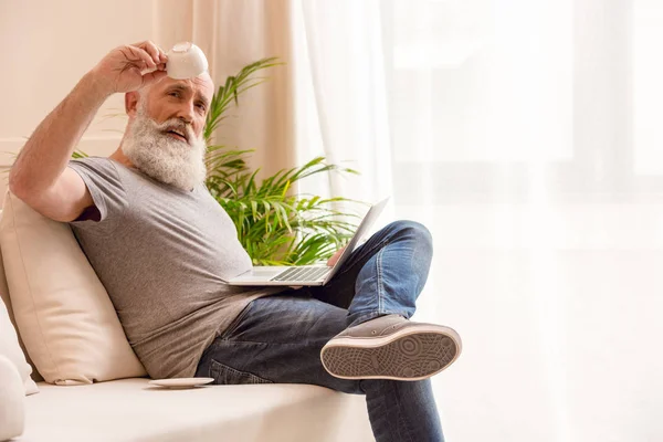 Senior man with empty coffee cup — Stock Photo