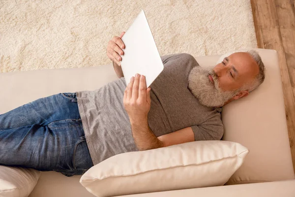 Uomo anziano utilizzando tablet digitale — Foto stock