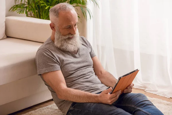 Senior man using digital tablet — Stock Photo