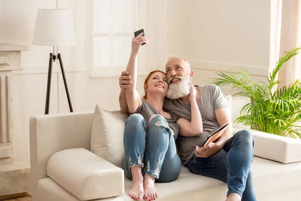 Casal maduro com dispositivos digitais — Fotografia de Stock