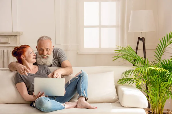 Feliz pareja madura con portátil - foto de stock