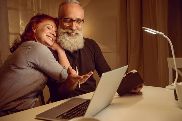 Couple d'âge moyen assis près d'un ordinateur portable — Photo de stock