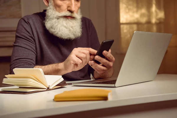 Hombre de pelo gris usando teléfono inteligente - foto de stock