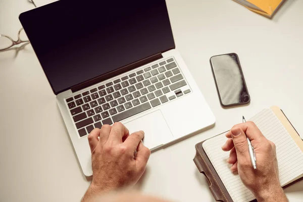 Homem sentado à mesa e usando laptop — Fotografia de Stock