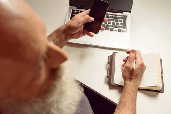 Grey haired man using smartphone — Stock Photo