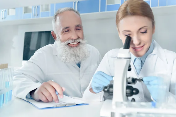 Cientistas em casacos brancos em laboratório — Fotografia de Stock