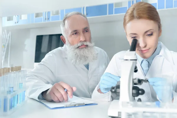 Científicos con batas blancas en el laboratorio - foto de stock