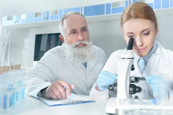 Cientistas em casacos brancos em laboratório — Fotografia de Stock