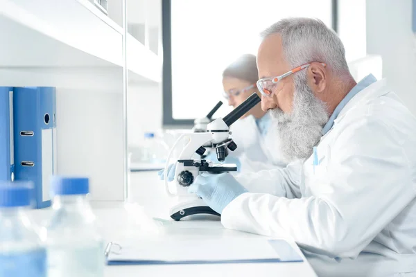 Científicos trabajando con microscopios - foto de stock