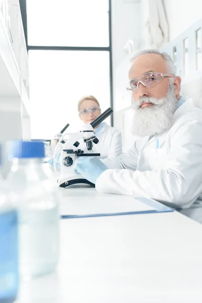 Científicos trabajando con microscopios - foto de stock