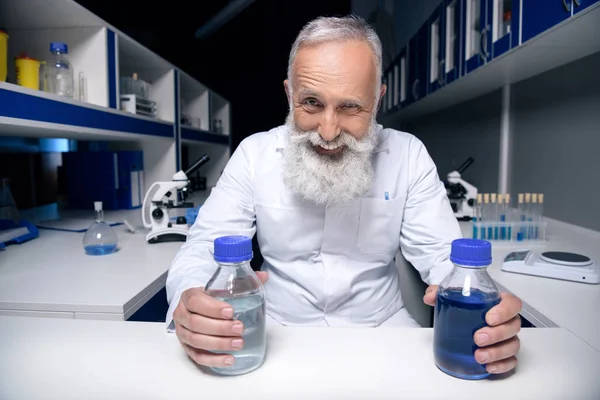 Scienziato che tiene bottiglie con reagenti — Foto stock
