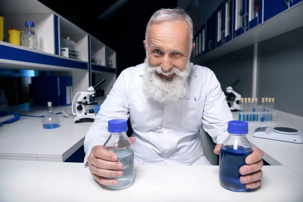 Scientist holding bottles with reagents — Stock Photo