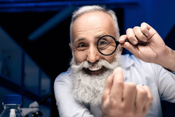 Scientist with magnifying glass — Stock Photo