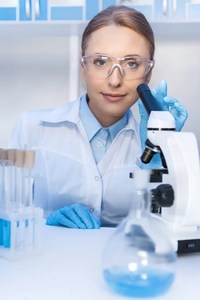 Científico usando microscopio en laboratorio - foto de stock