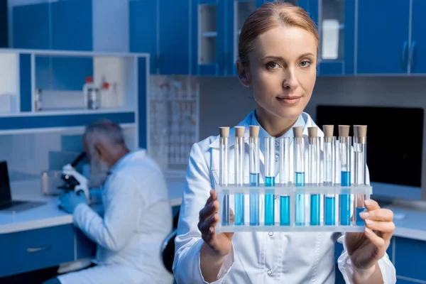 Técnico de laboratorio sosteniendo tubos - foto de stock