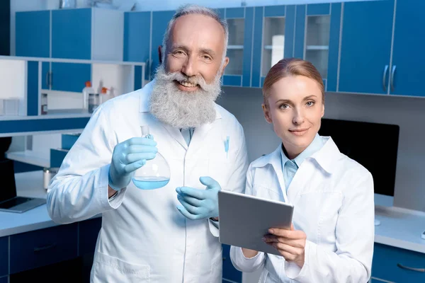 Chimistes en blouse de laboratoire regardant caméra — Photo de stock