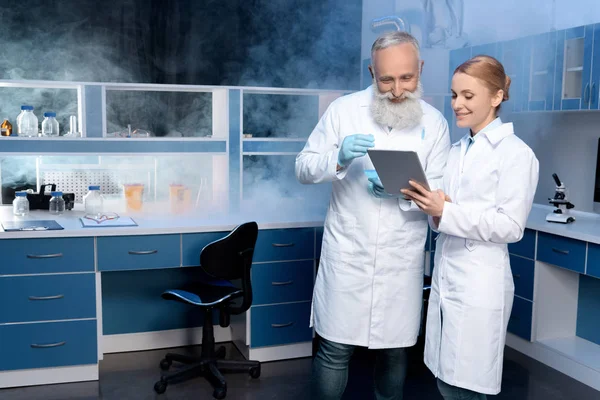 Techniciens de laboratoire regardant tablette numérique — Photo de stock