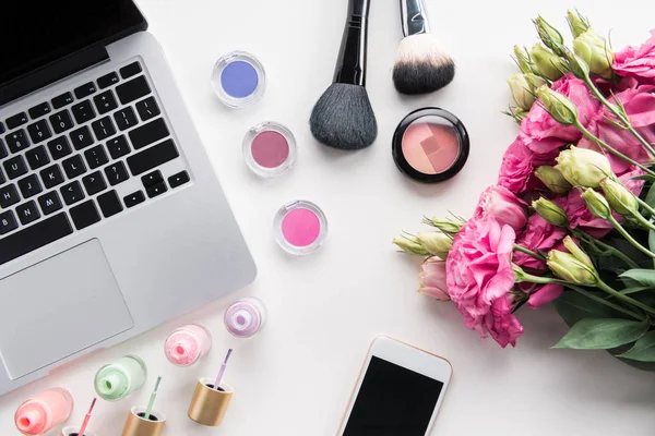 Divers cosmétiques et ordinateur portable sur table — Photo de stock