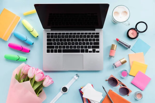 Divers cosmétiques et ordinateur portable sur table — Photo de stock