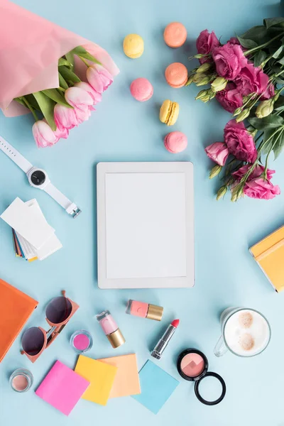 Tablet, various accessories and flowers on tabletop — Stock Photo