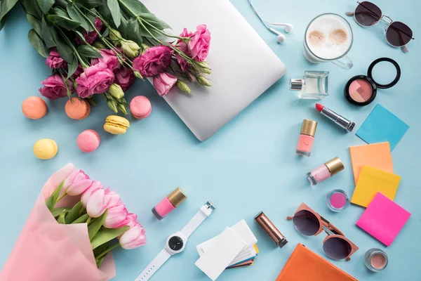 Fleurs avec ordinateur portable et lunettes de soleil avec des cosmétiques — Photo de stock