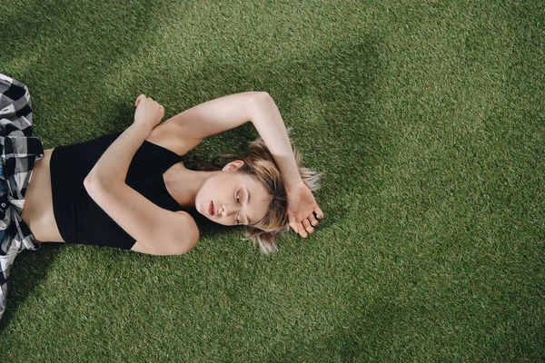 Junge Frau liegt auf Gras — Stockfoto