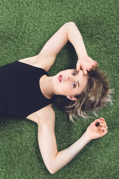 Jeune femme caucasienne couché sur l'herbe — Photo de stock