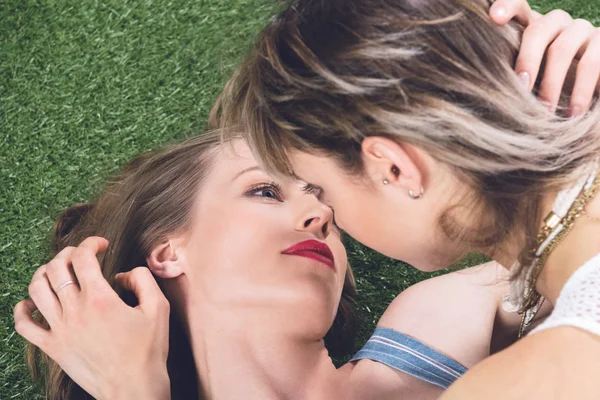 Homosexual couple kissing while lying on grass — Stock Photo