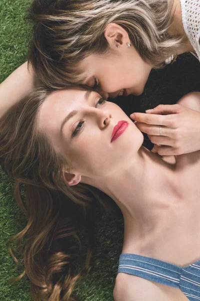 Couple lesbienne couché sur l'herbe — Photo de stock