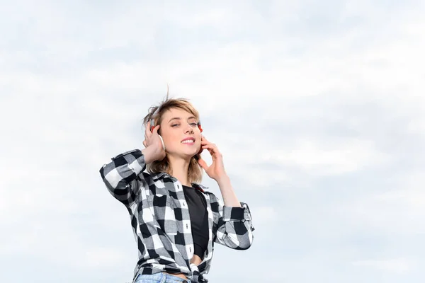 Femme écoute de la musique dans les écouteurs — Photo de stock