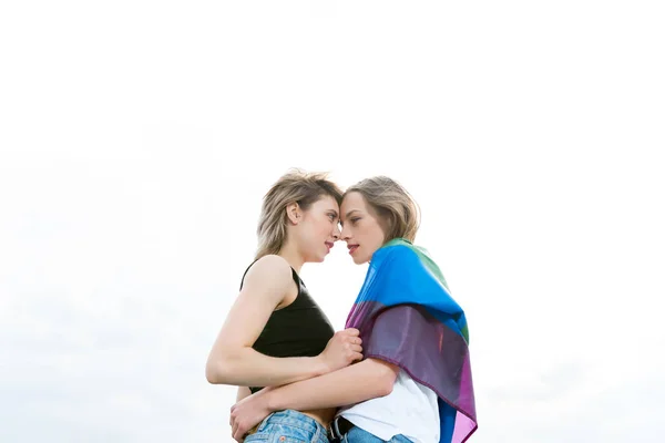 Homosexual pareja abrazando con lgbt bandera - foto de stock