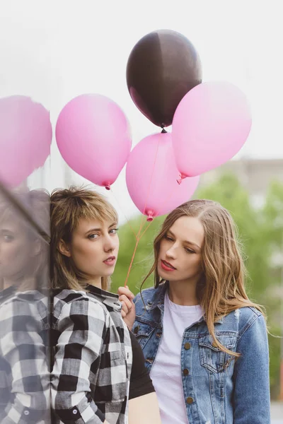 Lesbian couple holding air balloons — Stock Photo