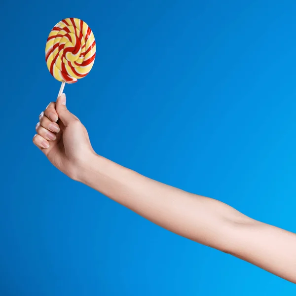 Hand holding lollipop — Stock Photo