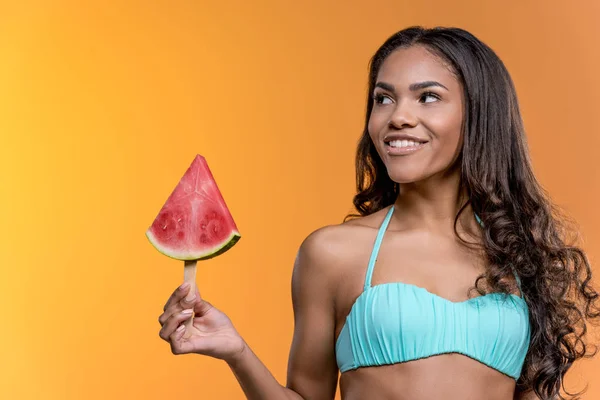 Frau in Badehose hält Wassermelonenstück in der Hand — Stockfoto