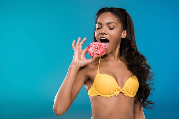 Chica afroamericana comiendo donut - foto de stock