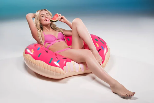 Frau isst Wassermelone auf Schwimmring — Stockfoto
