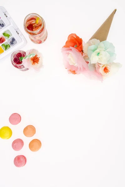 Flowers with macaroons and beverages — Stock Photo
