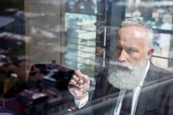 Concentrated mature bearded businessman — Stock Photo