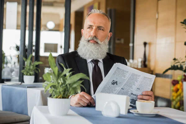 Pensativo hombre de negocios con periódico - foto de stock