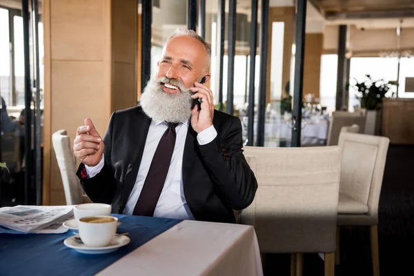 Businessman talking by phone in restaurant — Stock Photo