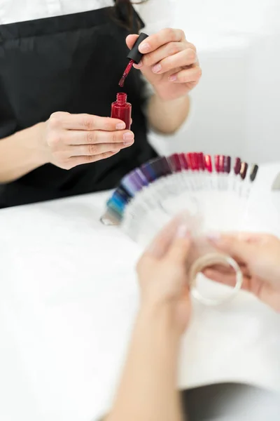 Mujer elegir color esmalte de uñas - foto de stock