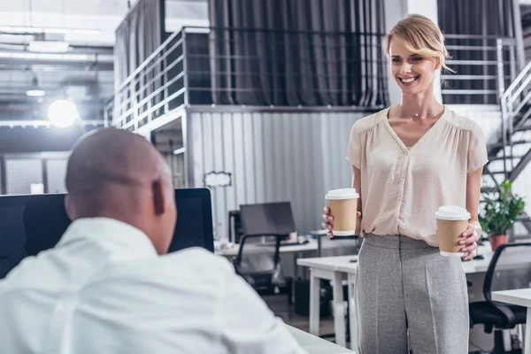 Businesswoman bringing coffee to colleague — Stock Photo