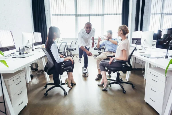 Businessman on skateboard in office — Stock Photo