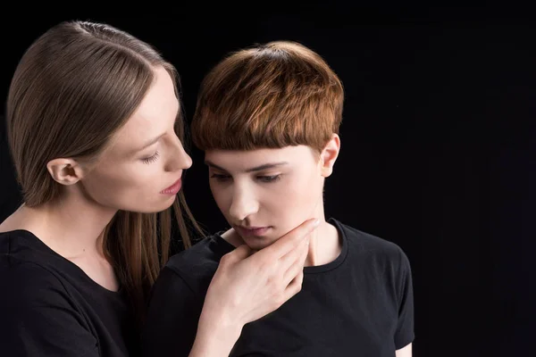 Young woman holding girlfriend by chin — Stock Photo